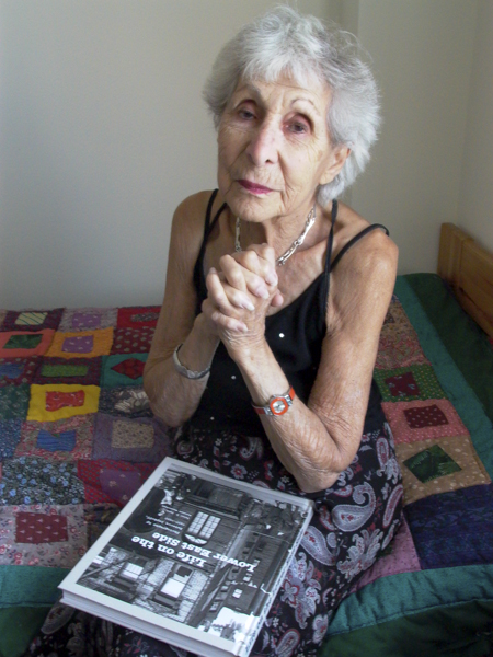 Rebecca Lepkoff at home with her first published book and her handmade quilt. Photo by Ellen Wallenstein.